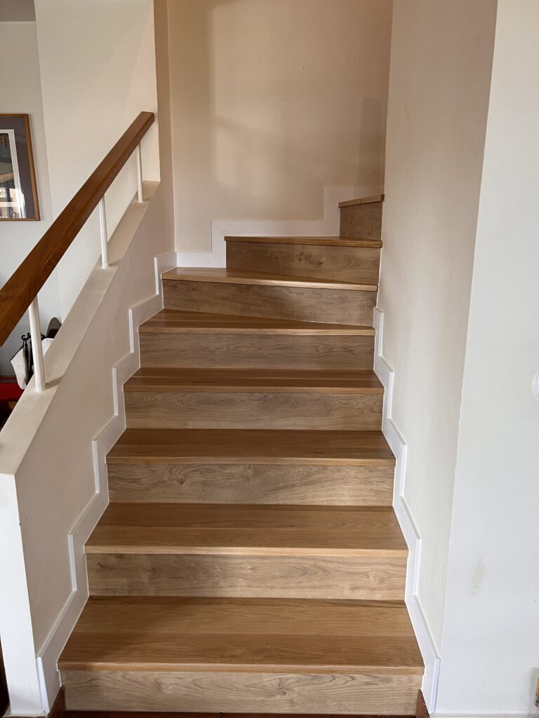 Escalera revestida en madera peldaño a peldaño por Tarimas Loor